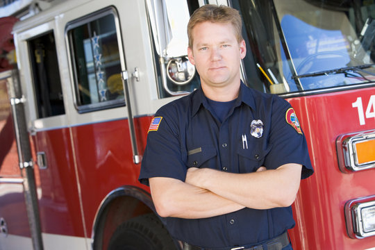 Portrait of a firefighter by a fire engine