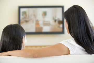 Woman and young girl in living room with flat screen television