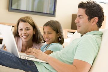 Obraz premium Family in living room with laptop smiling