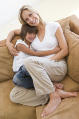 Obraz premium Woman and young girl sitting in living room smiling