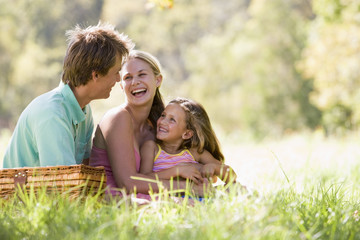 Family at park having a picnic and laughing