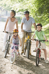 Obraz premium Family sitting on bikes on path smiling