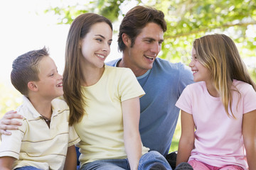 Family sitting outdoors smiling