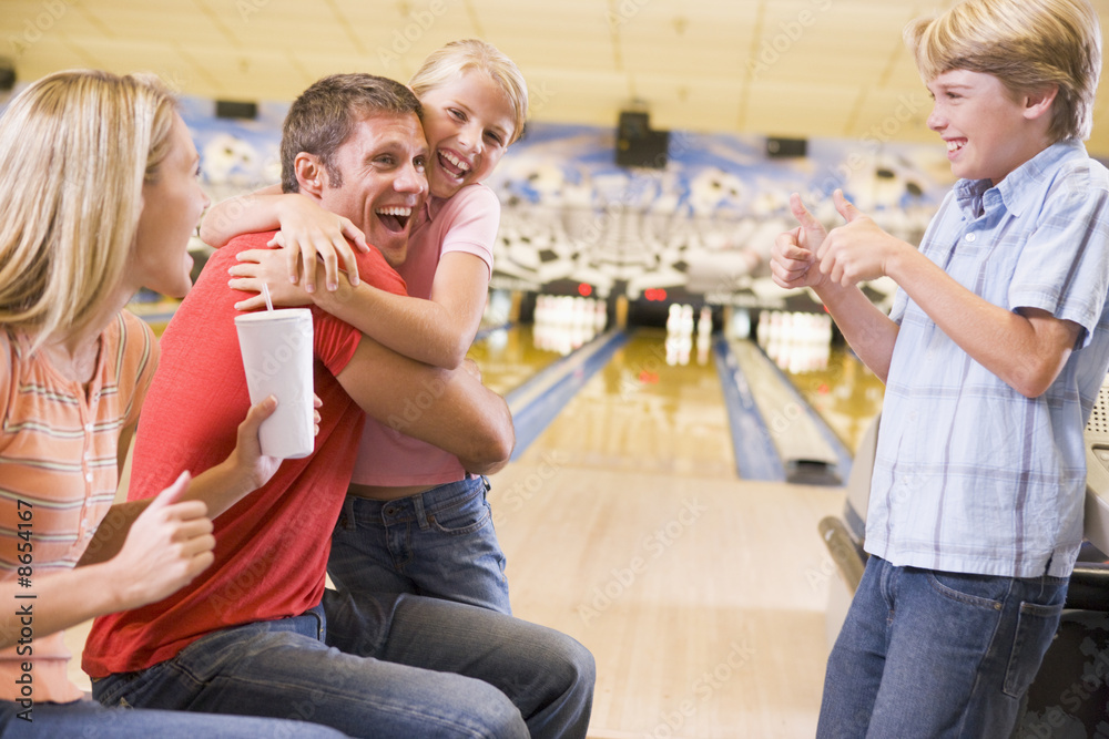 Wall mural Family in bowling alley cheering and smiling