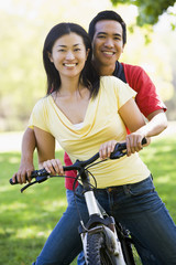 Obraz premium Couple on a bike outdoors smiling