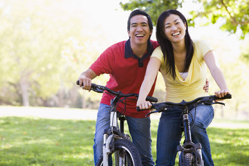 Fototapeta na wymiar Couple on bikes outdoors smiling