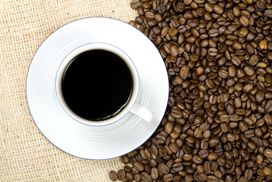 coffee cup from above with coffee beans and burlap background
