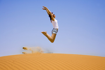 Young girl jump on the sand