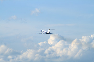 Fototapeta na wymiar Nowoczesny samolot pasażerski lecący w błękitne niebo z chmurami
