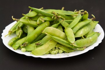 Peas pods on a white plate