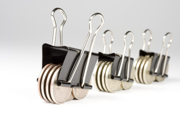Coins clamped by a paper clip