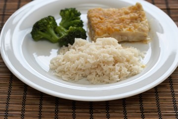 Reis, Fisch und Broccoli auf Teller