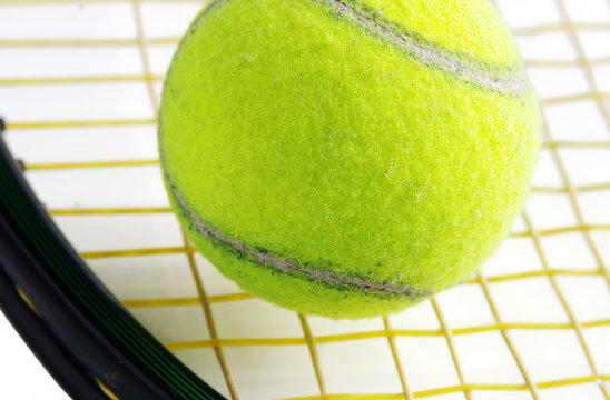 Closeup of a tennis ball and racket