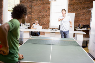 Obraz premium Two men in office space playing ping pong