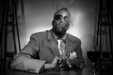 a stylish african american smoking his cigar