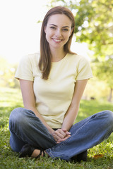 Obraz premium Woman sitting outdoors smiling