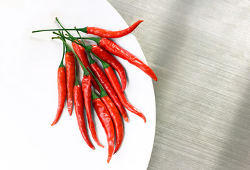 Hot Red Cayenne Peppers on White Plate on Stainless Counter