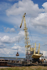 Fototapeta na wymiar Rozładowuje portu pogłębiarka piasek z barki