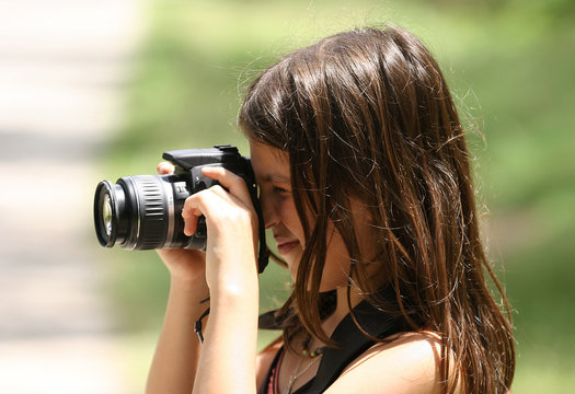 petite fille entrain de photographier avec un reflex num&eacute;rique