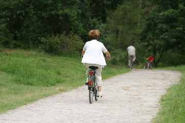 femme à la retraite entrain de faire du vélo en forêt