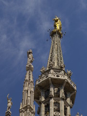 Fototapeta na wymiar Madonna en lo alto de la Catedral de Milan