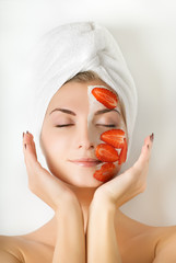 Beautiful woman with fruit mask on her face