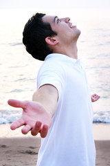 Young Hispanic Man with Arms Raised Praying