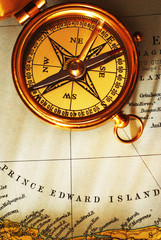 Antique brass compass over old Canadian map background