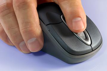 Macro detail of wireless computer mouse and hand