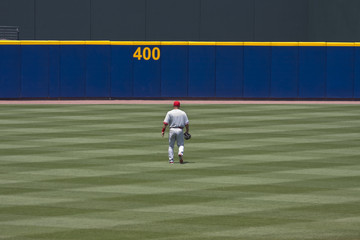 Baseball player walking to outfield