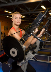 Fototapeta na wymiar Beautiful woman works out in a gym
