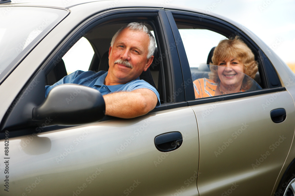 Poster Smiling happy elderly couple  in the new car.