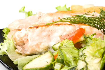 Stake from a salmon with vegetables on a plate. Closeup.