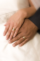 Obraz na płótnie Canvas Bride and bridegroom hands over wedding dress (wedding rings)
