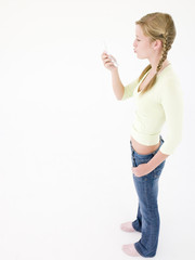 Teenage girl looking at cellular phone and puckering up