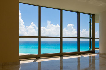 View of tropical beach through hotel windows