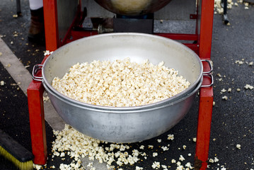 A tin basin filled with kettle corn at a county fair.