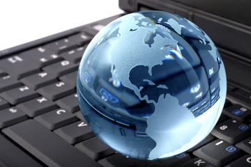 Blue glass globe on a laptop keyboard