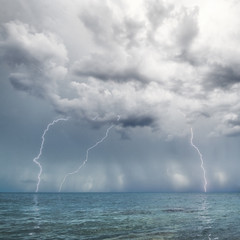 Lightning and thunderstorm above sea in the day