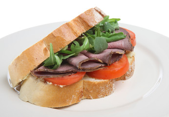 Rare roast beef in between thick slices of crusty white bread.