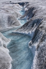 Narrow and fast creek on the top of glacier