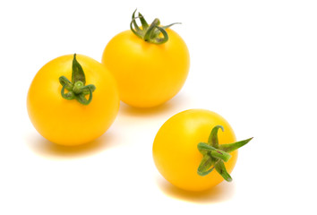 three yllow tomatoes on white background