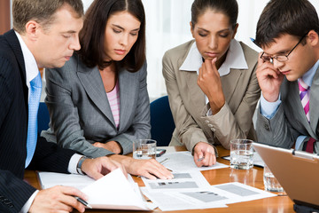Photo of business group sitting at the table