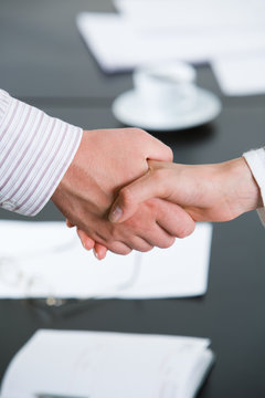 Photo of partners’ hands making agreement by handshaking