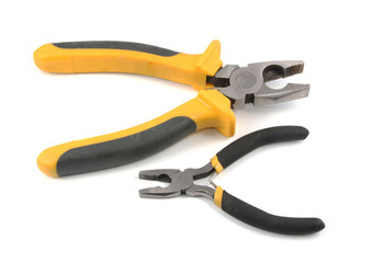 Obraz premium The big and small flat-nose pliers lay on a white background.