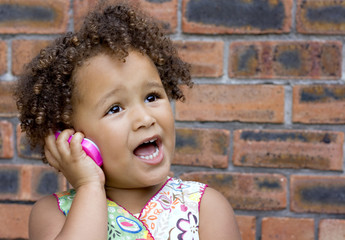 Young black baby girl talking on a toy cell phone - 8843138