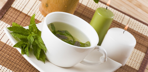cup of mint tea and fresh leaves