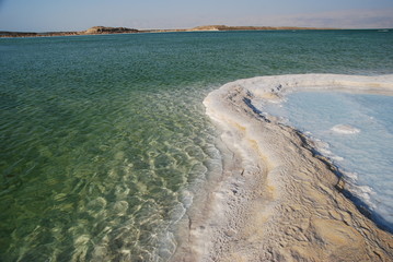 Salt on dead sea in the rays of sunset by evening