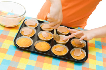 Fototapeta premium Child icing fairy cakes, close up and angled