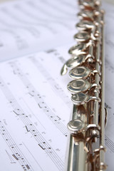 Fototapeta premium open music book with notes and silver flute